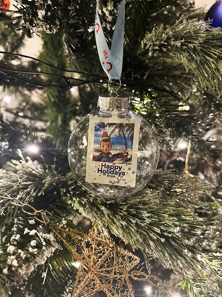 TUI Elf-inspired personalised bauble hanging on a Christmas tree